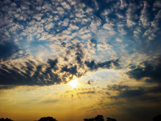 The sky with white-black clouds and sunrise beam,