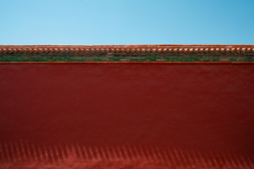 Chinese traditional red wall with blue sky. Minimal background.