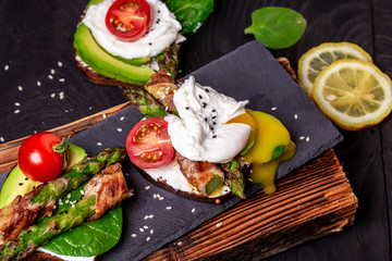 Grilled toast with asparagus in bacon and poached egg. Food recipe background. top view