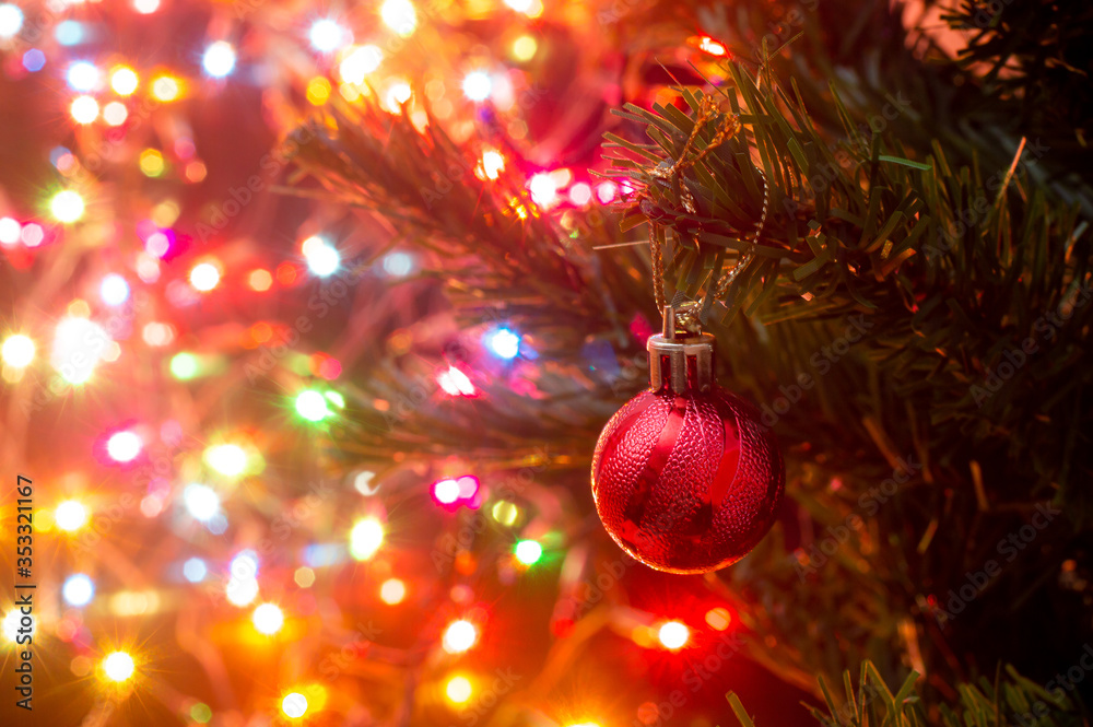 Wall mural red chritmas ball hankiing on tree with colorful bokeh background