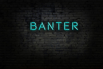 Neon sign with inscription banter against brick wall