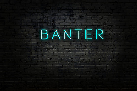 Neon sign with inscription banter against brick wall