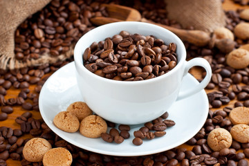 Composition with  coffee cup and tasty  almond cookies on wooden background