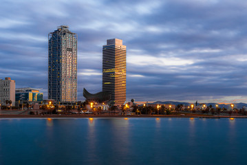 Obraz premium Vista nocturna de las torres Mapfre en la playa de la Barceloneta