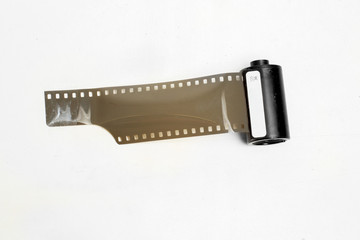 vintage photographic film with perforations in cassette on white background isolate