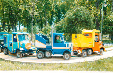Amusement park. A little boy rides on a toy electric car on a sunny summer day.