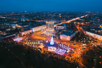 Fototapeta na wymiar Gomel, Belarus. Main Christmas Tree And Festive Illumination On Lenin Square In Homel. New Year In Belarus. Aerial Night View