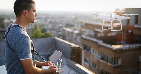 Man with drone flying at the city on rooftop