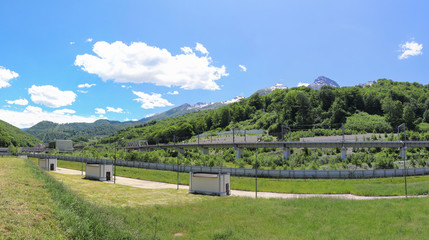 Beautiful futuristic modern water intake pumping wells against the background of mountains and snow peaks. Sochi, Russia.