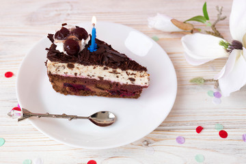 A piece of chocolate cake for the birthday, cake with a corned candle