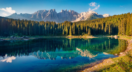 Calm summer view of Carezza (Karersee) lake. Stunning morning scene of Dolomiti Alps, Province of Bolzano, South Tyrol, Italy, Europe. Beauty of nature concept background.