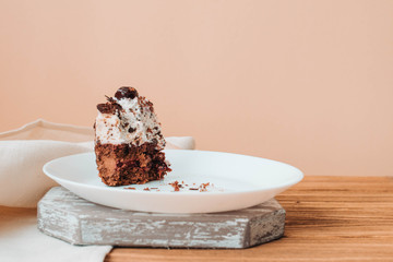 Half-eaten piece of cake on a plate, leftover chocolate cake with cherries