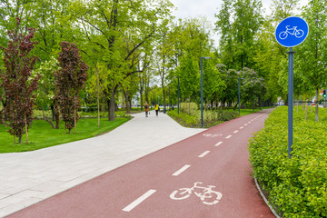 Sustainable transport. Blue road sign or signal of bicycle lane, road bike with green trees and...