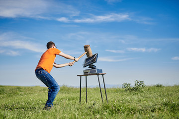 young man hitting a computer screen with a big gavel