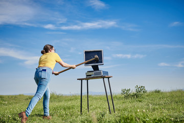 young woman tearing up a computer in the field