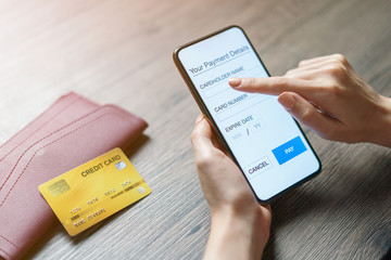 Mobile payments. hands using smartphone and credit card for online shopping. (Fake Screen)