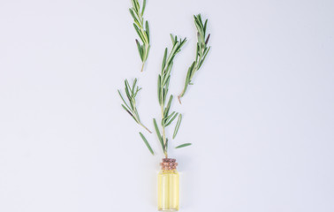 Fototapeta na wymiar Top view Bottle glass of essential rosemary oil with rosemary on wooden rustic background. herbal oil concept
