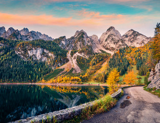 Magnificent autumn view of Gosausee (Vorderer) lake with asphalt walkway road. Spectacular morning scene of Austrian Alps, Upper Austria, Europe. Beauty of nature concept background.