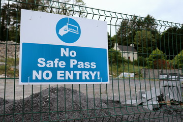 No Safe Pass, No Entry sign, hanging on a construction bulding site fence
