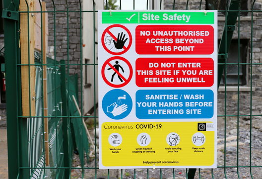 covid-19 safety regulations sign on a building site fence