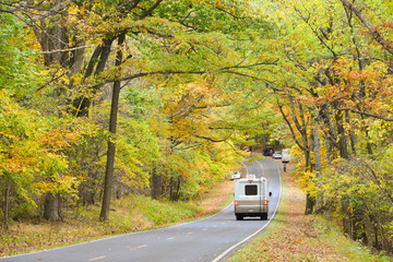 A RV goes into the forest during autumn - Shenandoah National Park, Virginia, United States of America