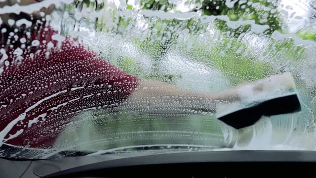 close up, man's hand washes car windshield Concept of Auto service, Car Wash