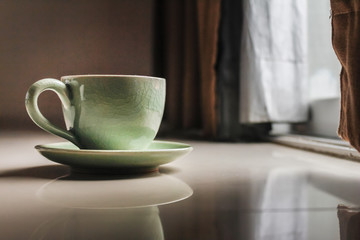 Smooth Focus and soft Focus,Hot coffee in a cup of coffee placed on the bedroom floor by the window in the morning was placed to prepare for drinking coffee before work.