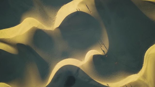 Stunning 4K aerial shot of sand dunes in desert while sunset from above. Maspalomas, Gran Canaria in Spain