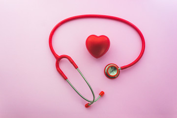 Red stethoscope and .the heart on pink background with copy space.