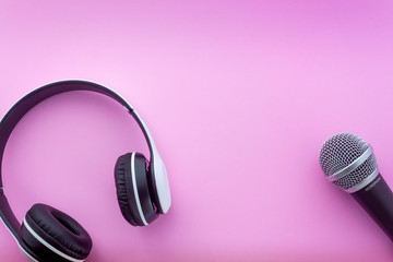 Headphone and microphone on pink background in top view