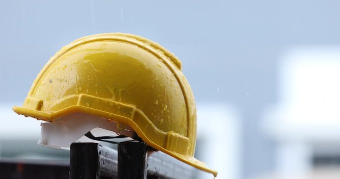 Raindrops on a yellow helmet, heavy rain, storm, construction helmet, construction site