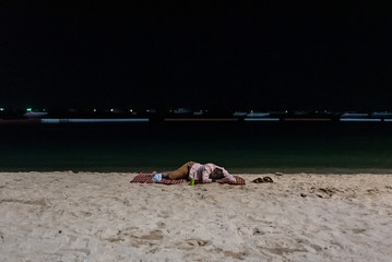 Fototapeta na wymiar Man sleeping on a beach in Pattaya, Thailand