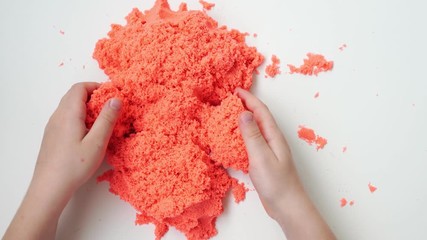 games with kinetic sand. pours through fingers on table.development motor skills - Powered by Adobe