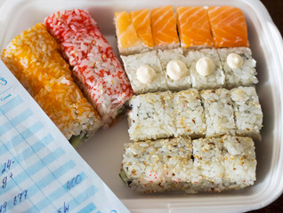 home delivery of sushi in a single-use package and a receipt with an invoice