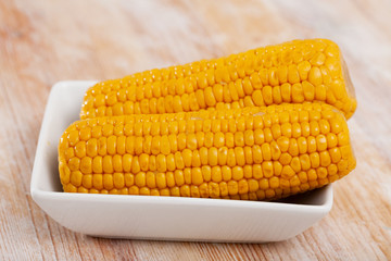 Delicious sweet boiled corn cobs on plate. Healthy food concept