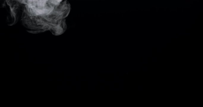 smoke swirling into frame against a black background.