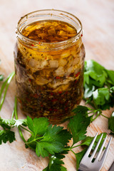 Marinated herring with onions and spice in a glass jar
