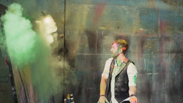 The artist throws colored paints on the canvas of Karina with explosions