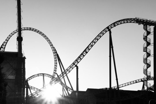 Black and white image, silhouettes of roller coasters. Background texture. Amusement park.