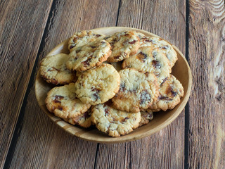 Fresh juicy date cookies in a bowl on a brown wooden surface