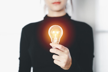 Hand of business female holding a light bulb for accounting and creative concept.