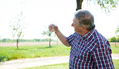 alter Mann sieht sich den Regenmesser an, Regenmenge, Mann, Sommer, Garten