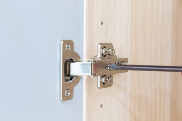 Polished Stainless door hinge on a cabinet door for interior design.