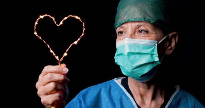 Medico o infermiere donna Italiana tiene in mano il simbolo del cuore