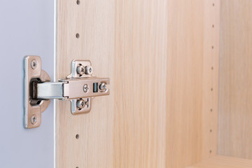 Polished Stainless door hinge on a cabinet door for interior design.