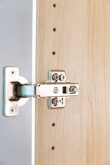 Polished Stainless door hinge on a cabinet door for interior design.