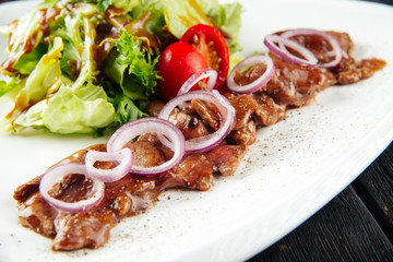 Gourmet cooked beef meat sauce onion ring salad 