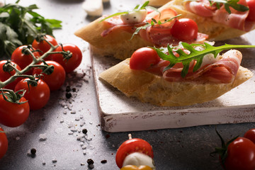 Delicious bruschetta with bacon, mozzarella and cherry