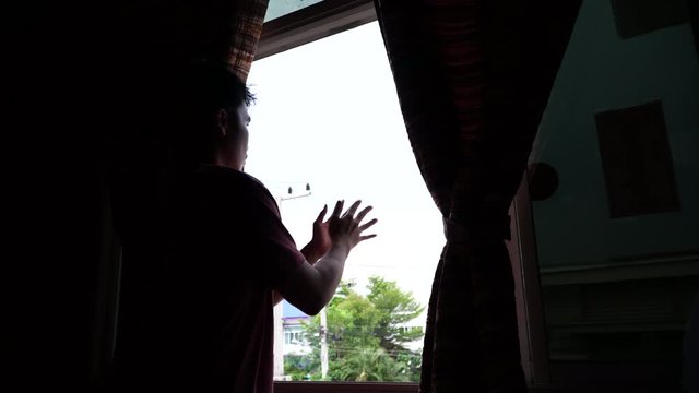 man clapping in the window in support of people who fight against the coronavirus.