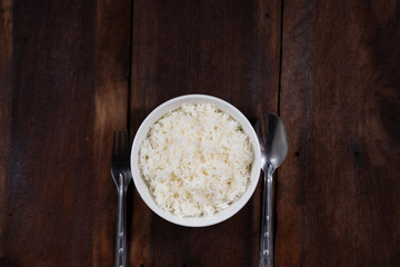 Cooked Thai jasmine rice on wooden background - vintage filter